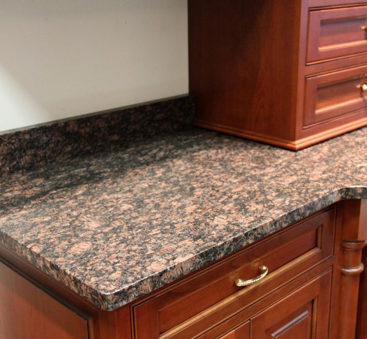 close up of kitchen countertop pattern on top of cherry cabinets