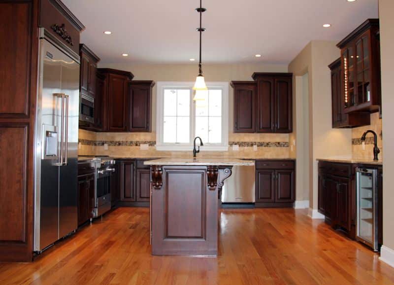 cherry kitchen cabinets in newly remodeled kitchen with three separate countertops